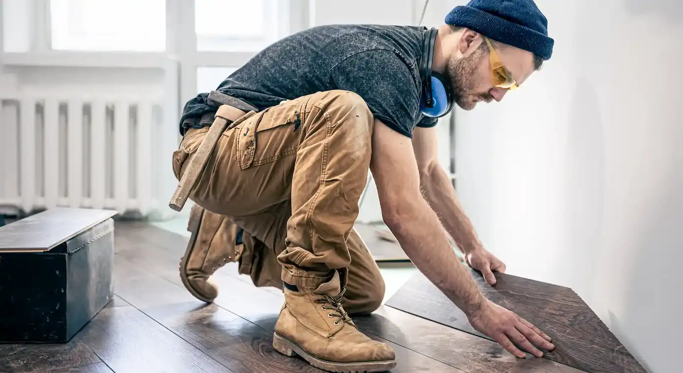 a male worker puts laminat flooring on the floor